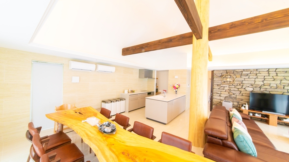 石垣島ザミヤラガーデンのリビングスペース　システムキッチン　ソファ　机などもある